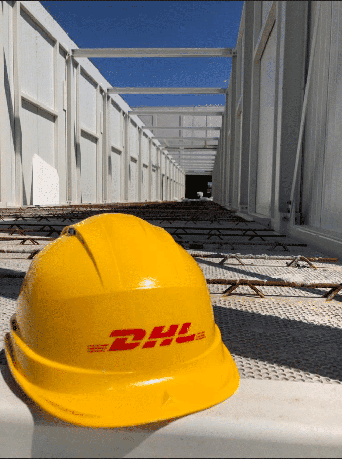 yellow DHL safety helmet lies on the ground in the yard of new CityHub Antwerp.