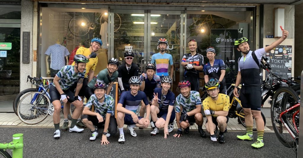 A group of people posing, wearing Peloton de Paris cycling gear in Japan