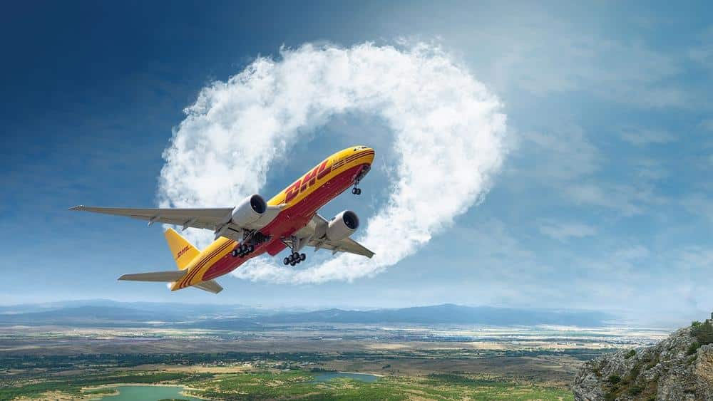 DHL plane flying through a blue sky.