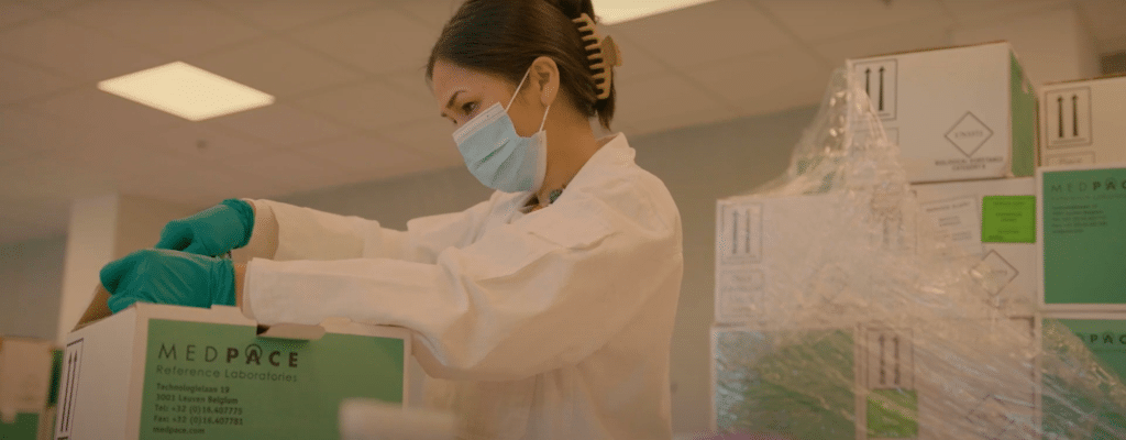 Vrouwelijke Medpace medewerker opent doos met medische materialen