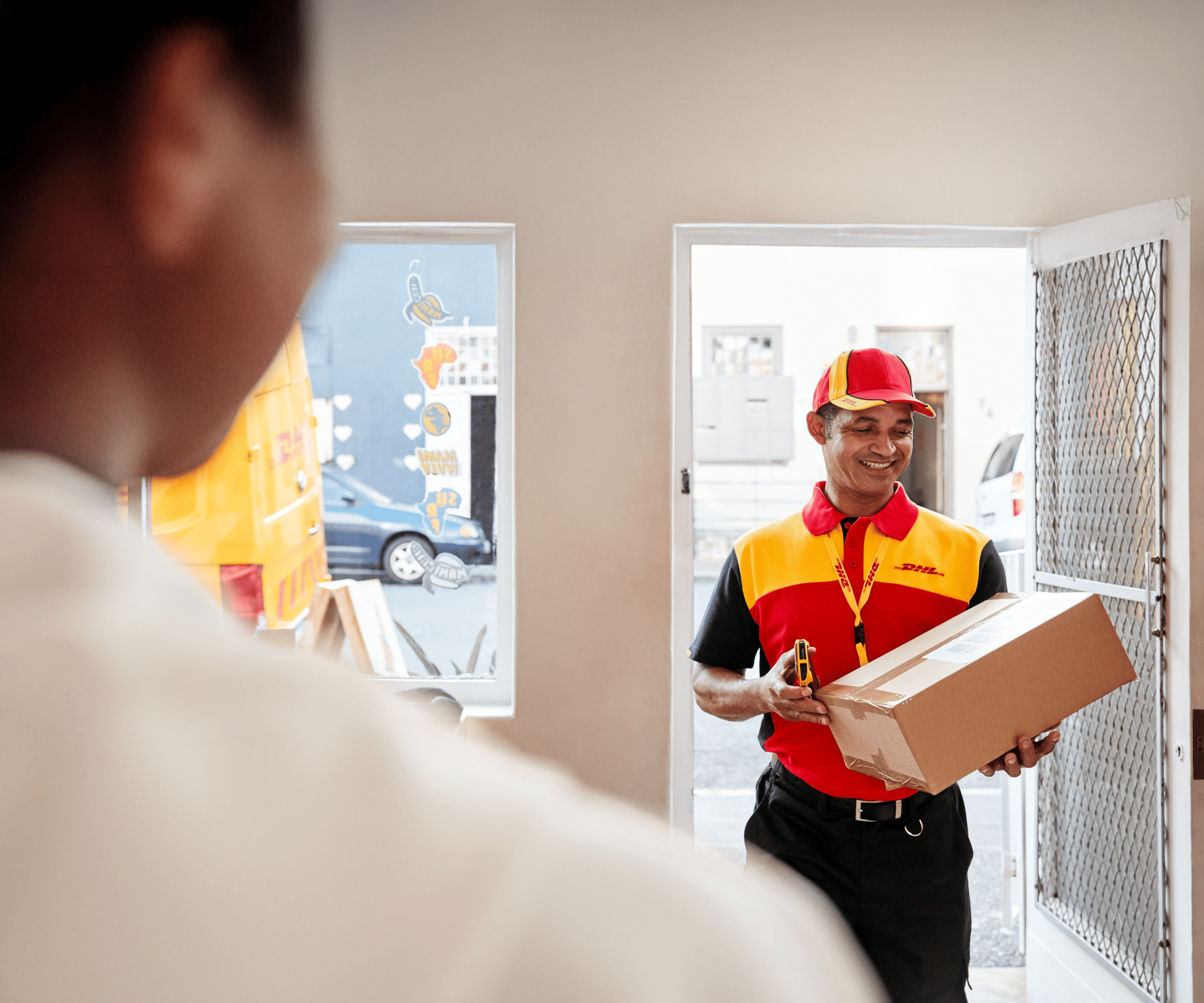 Courrier walks in shop carrying a parcel